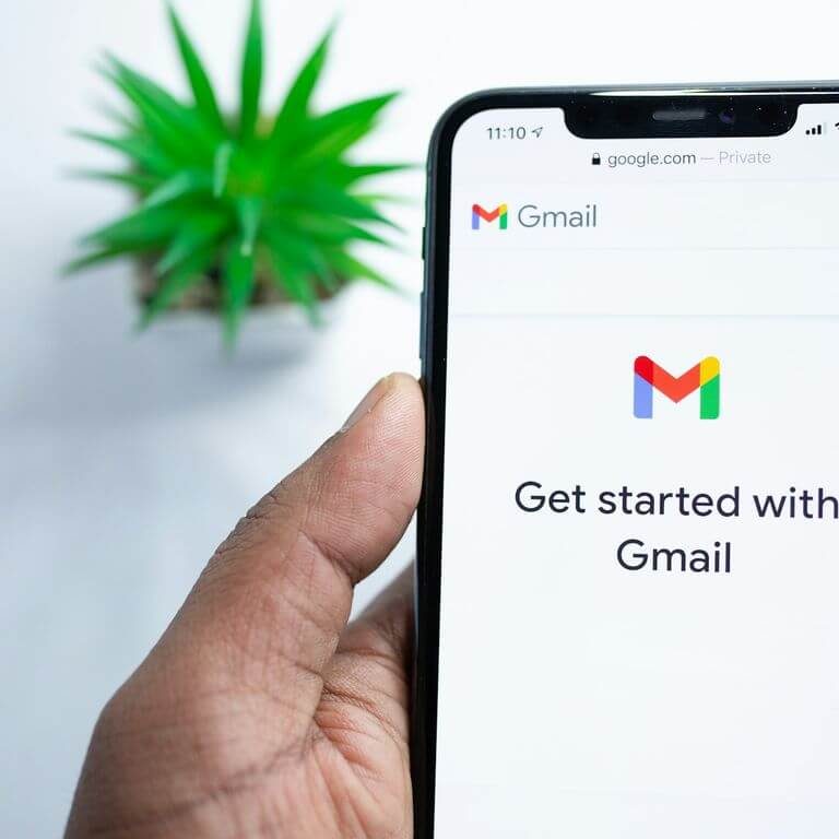 Hand hält Smartphone mit Gmail-Startseite und der Aufforderung „Mit Gmail beginnen“.